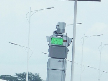 An einer stark befahrenen Verkehrskreuzung in Kinshasa regelt ein Ampel-Roboter den Verkehr.