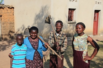 Spéciose Mukamurenzi und ihr Mann Jean Mbonyumugenzi arbeiten als  ehrenamtliche Familienhelfer in ihrem Heimatdorf. Hier: Mit ihren Kindern vor dem Haus.